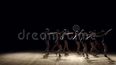 一群年轻的芭蕾舞女在黑暗中<strong>上台</strong>跳舞，特写。